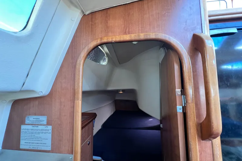 Slide: The Image of Interior cabin view of 2013 Gemini Legacy 35 sailboat with wooden door and cozy sleeping area. - 97