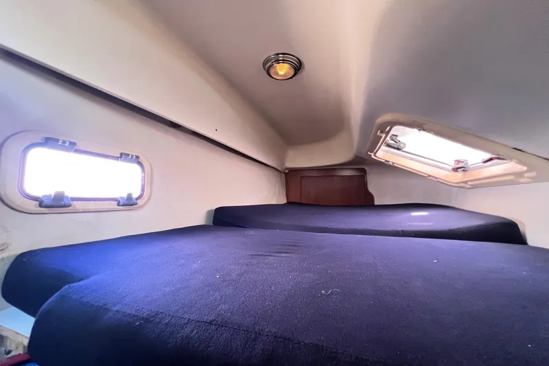 Slide: The Image of Interior cabin of 2013 Gemini Legacy 35 sailboat with cozy bedding and portholes. - 100