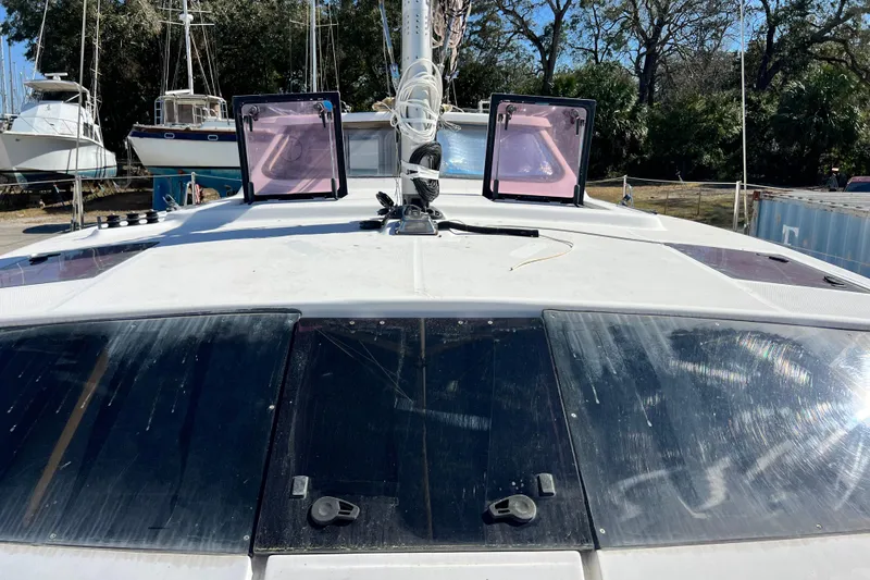 Slide: The Image of 2013 Gemini Legacy 35 catamaran deck with hatches and rigging, docked in a boatyard. - 56