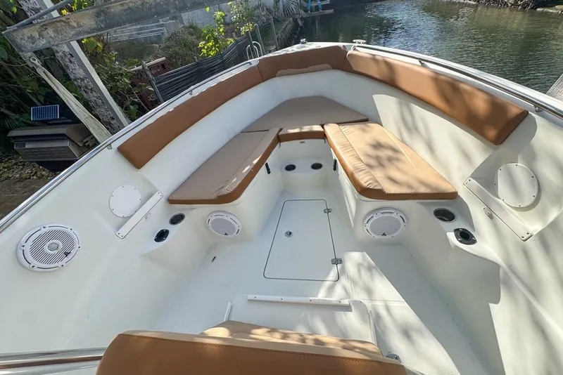 Slide: The Image of 2005 Sailfish 2660 CC boat interior with tan cushions and white speakers. - 11