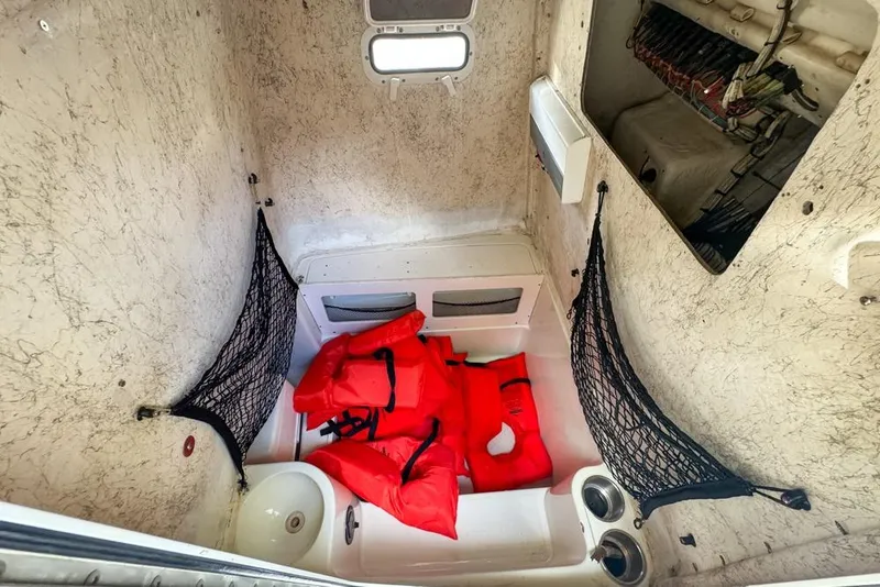 Slide: The Image of 2005 Sailfish 2660 CC cabin interior with red life jackets and storage nets. - 47