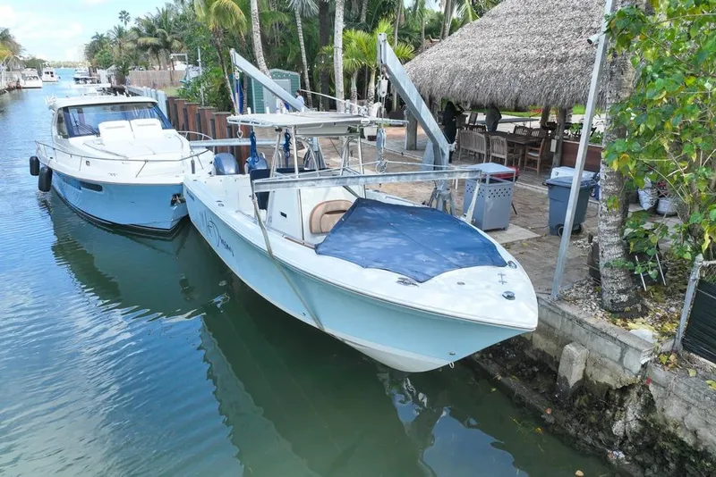 Slide: The Image of 2005 Sailfish 2660 CC boat docked beside another vessel in a tropical setting. - 1