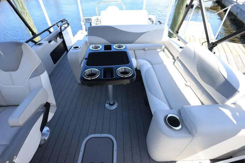 Slide: The Image of 2025 Tahoe Pontoon LTZ 23 interior with sleek seating and table, docked by the water. - 13