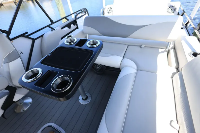Slide: The Image of 2025 Tahoe Pontoon LTZ 23 interior with sleek seating and cupholders on a sunny day. - 14