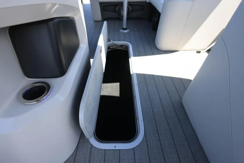 Slide: The Image of 2025 Tahoe Pontoon LTZ 23 interior with open storage compartment on deck. - 16