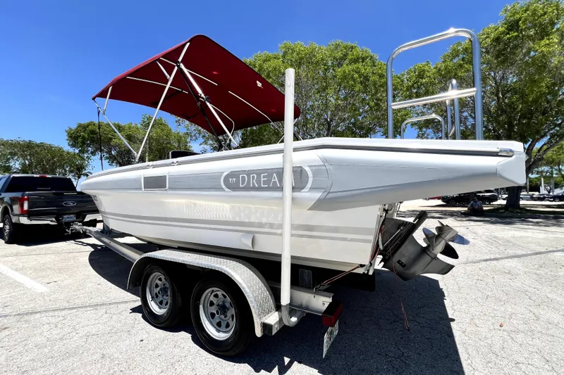 Slide: The Image of 2013 Novurania Chase 23 boat on trailer with red canopy in parking lot. - 13