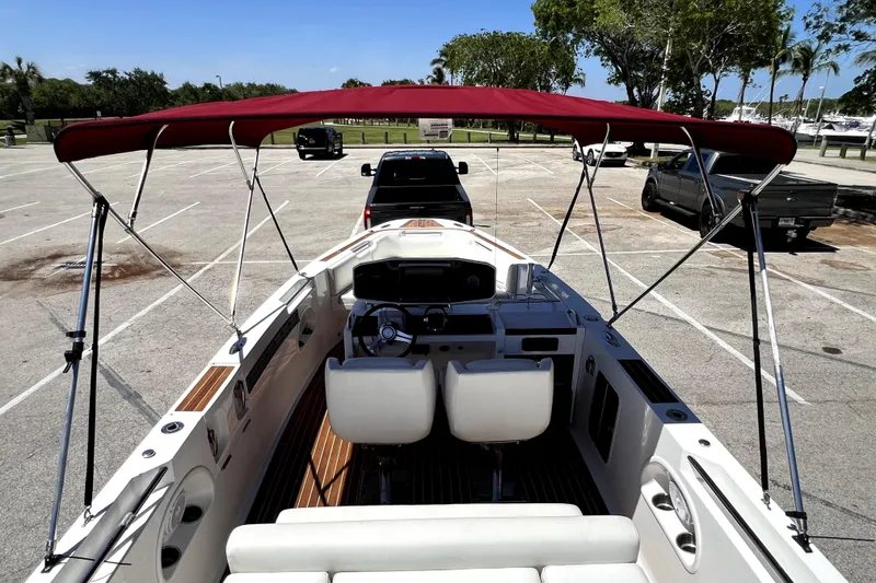 Slide: The Image of 2013 Novurania Chase 23 boat with red canopy in parking lot. - 42