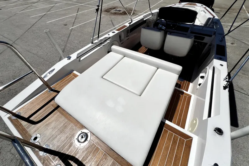 Slide: The Image of 2013 Novurania Chase 23 boat interior with white seating and wooden deck. - 34