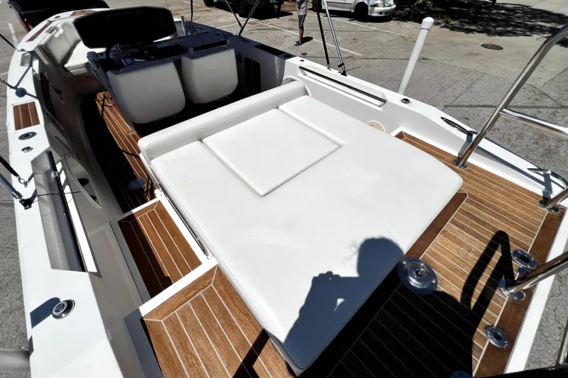 Slide: The Image of 2013 Novurania Chase 23 boat interior with white seating and wooden deck. - 73