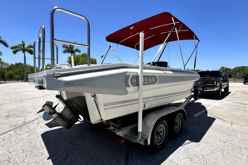 Slide: The Image of 2013 Novurania Chase 23 boat on trailer with red canopy in sunny parking lot. - 3