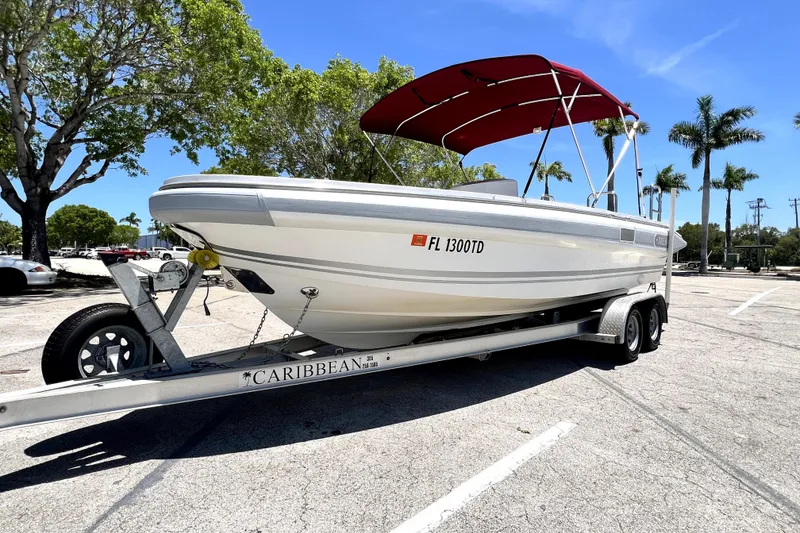 Slide: The Image of 2013 Novurania Chase 23 boat on trailer with red canopy, parked under sunny skies. - 16