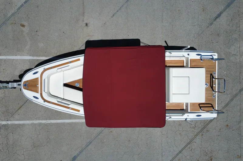Slide: The Image of Overhead view of 2013 Novurania Chase 23 boat with red canopy on concrete surface. - 29