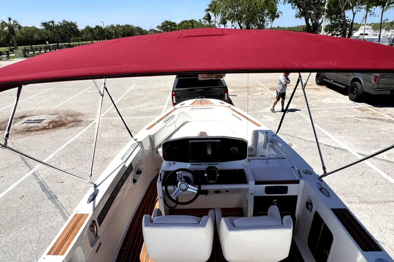 Slide: The Image of 2013 Novurania Chase 23 boat with red canopy in parking lot. - 83