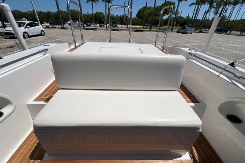 Slide: The Image of 2013 Novurania Chase 23 boat interior with white seating and wooden deck. - 85