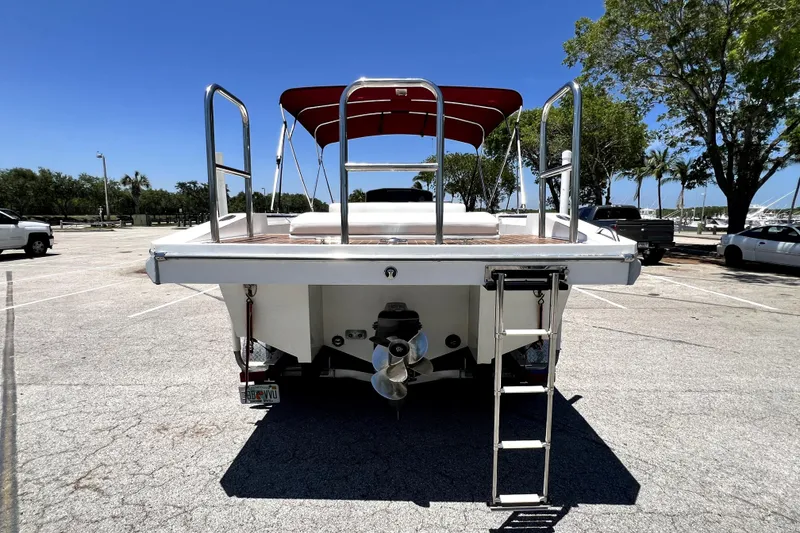 Slide: The Image of 2013 Novurania Chase 23 boat with ladder and red canopy in parking lot. - 6