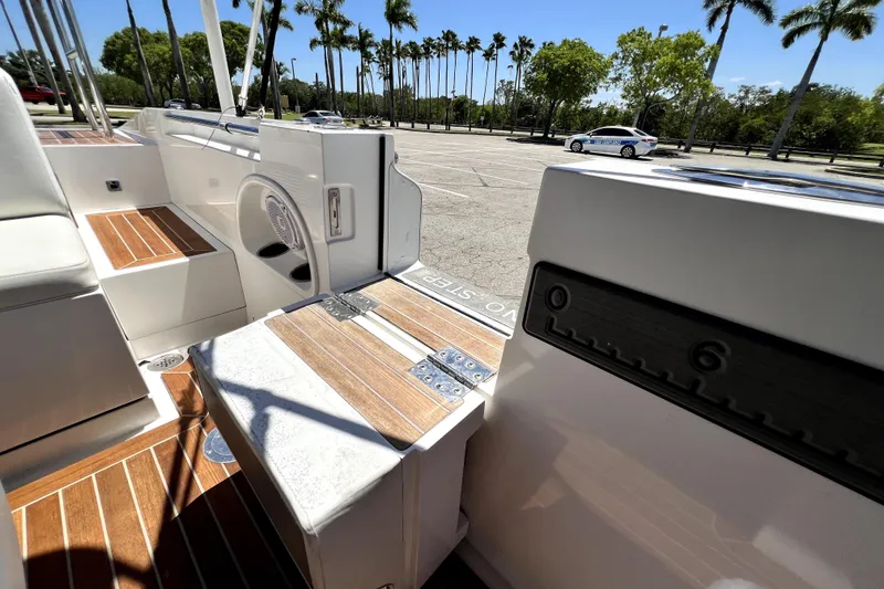 Slide: The Image of 2013 Novurania Chase 23 boat interior with wood accents, parked near palm trees. - 71