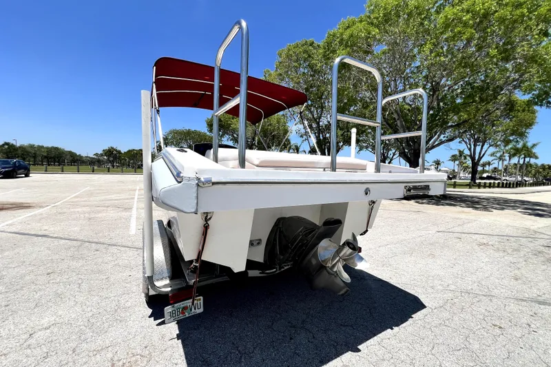 Slide: The Image of 2013 Novurania Chase 23 boat with red canopy, parked in sunny lot. - 12