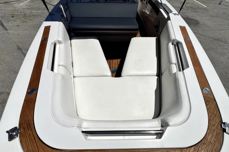 Slide: The Image of 2013 Novurania Chase 23 boat interior with white seating and wood accents. - 54