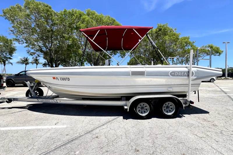 Slide: The Image of 2013 Novurania Chase 23 boat with red canopy on trailer in sunny parking lot. - 14