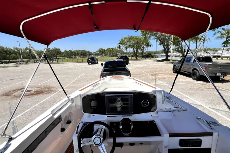 Slide: The Image of 2013 Novurania Chase 23 boat interior with red canopy in parking lot. - 32