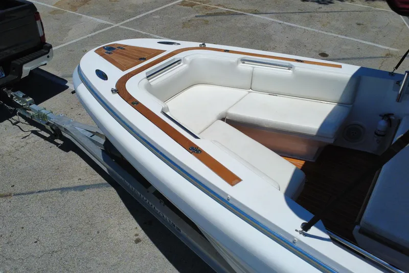 Slide: The Image of 2013 Novurania Chase 23 boat on trailer, featuring white seating and wood accents. - 25