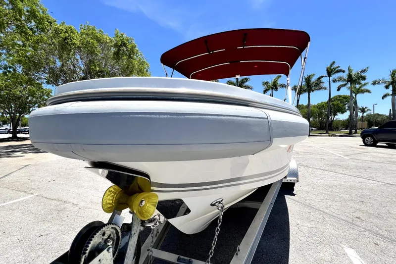 Slide: The Image of 2013 Novurania Chase 23 boat on trailer, red canopy, sunny day, palm trees in background. - 17