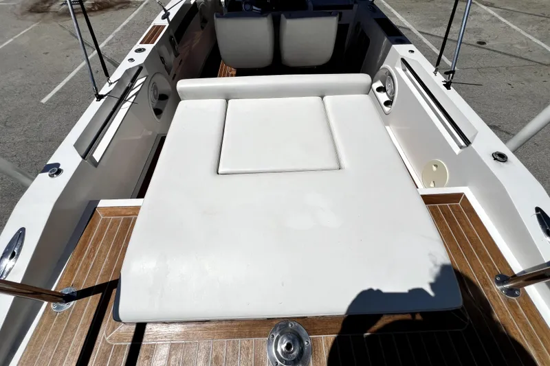 Slide: The Image of 2013 Novurania Chase 23 boat interior with white seating and wooden flooring. - 62