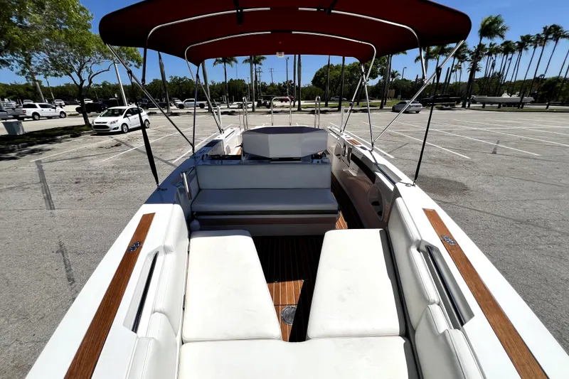 Slide: The Image of 2013 Novurania Chase 23 boat with white seating and red canopy in a parking lot. - 55