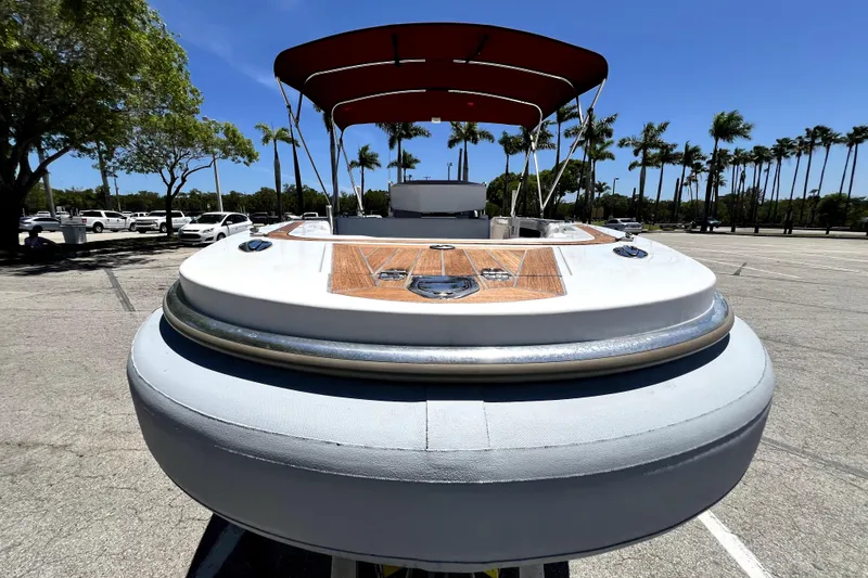 Slide: The Image of 2013 Novurania Chase 23 boat with canopy, parked in sunny lot with palm trees. - 21
