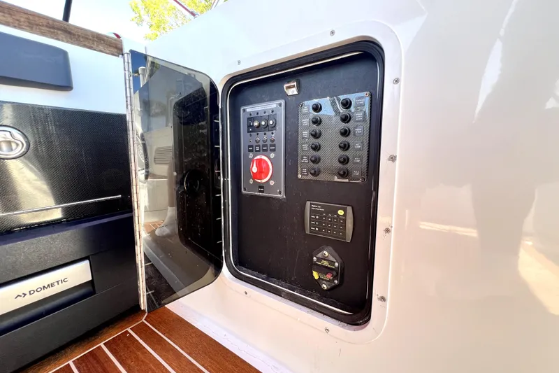 Slide: The Image of Control panel inside a 2013 Novurania Chase 23 boat, featuring switches and a red button. - 70