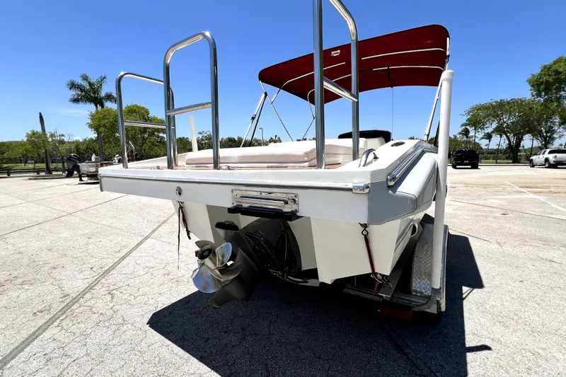 Slide: The Image of 2013 Novurania Chase 23 boat with red canopy, parked on a sunny day. - 4