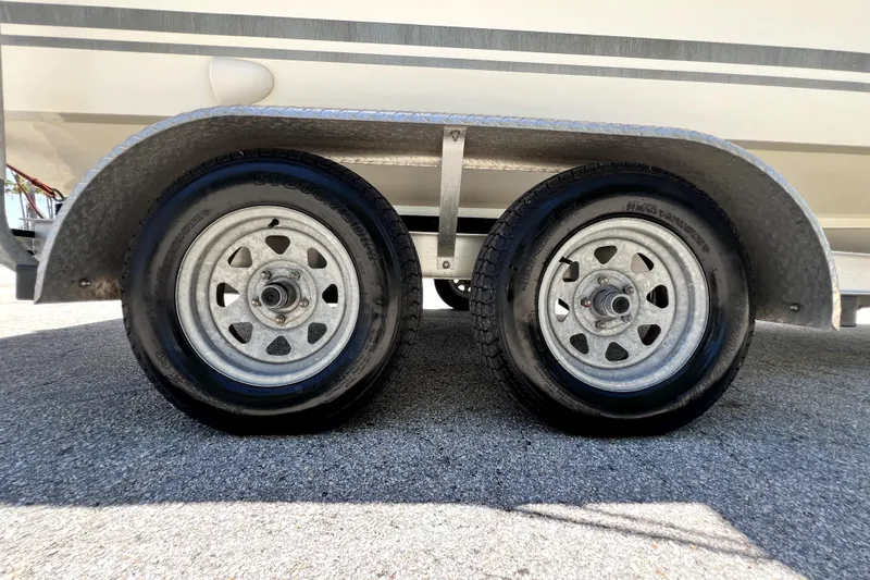 Slide: The Image of Trailer wheels of a 2013 Novurania Chase 23 boat on pavement. - 2