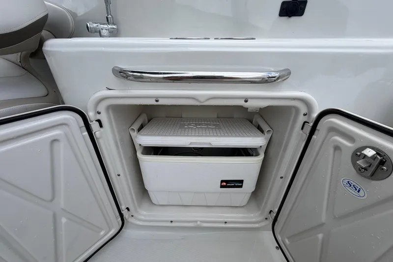 Slide: The Image of 2012 Crownline 236 SC boat storage compartment with cooler inside. - 27