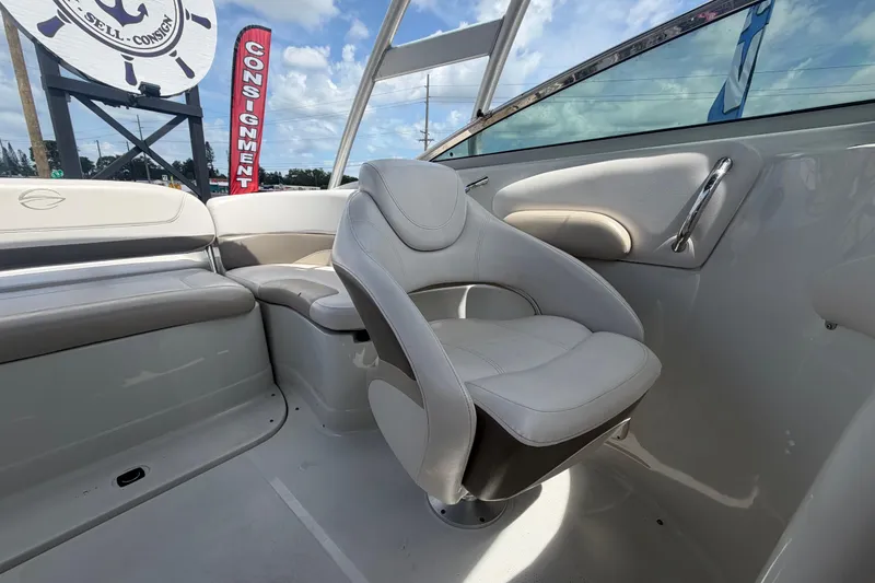 Slide: The Image of 2012 Crownline 236 SC boat interior with plush seating and consignment sign in background. - 80