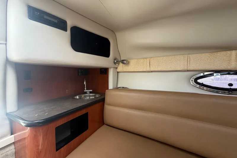 Slide: The Image of Interior of 2012 Crownline 236 SC boat with kitchenette and seating area. - 58