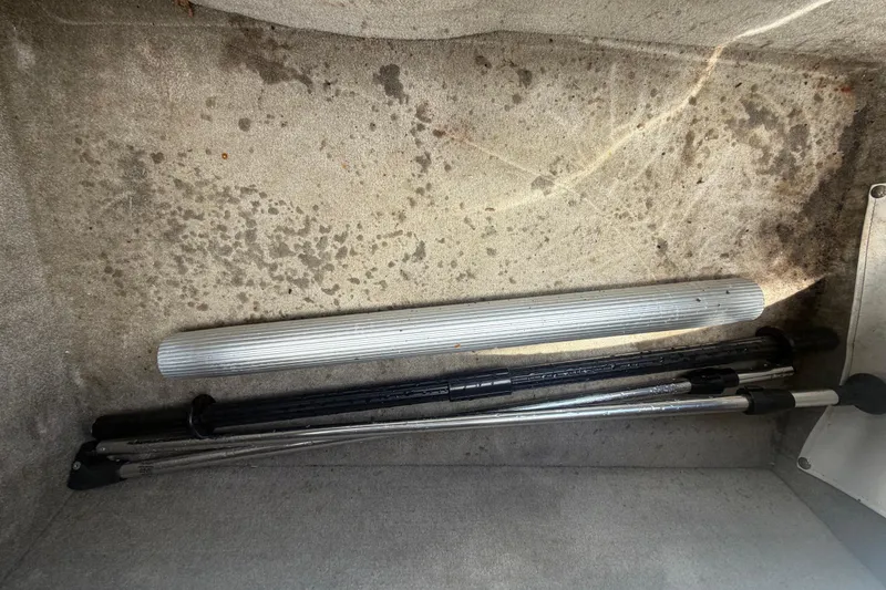 Slide: The Image of Storage compartment of a 2012 Crownline 236 SC boat with metal poles and carpeted interior. - 86