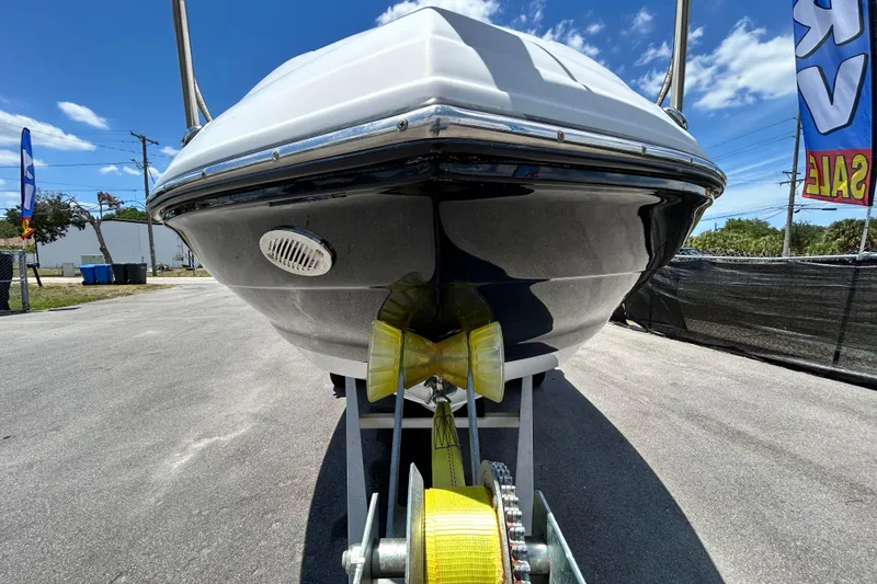 Slide: The Image of 2012 Crownline 236 SC boat on trailer, sunny day, sale banners visible. - 11
