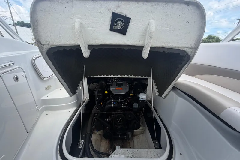 Slide: The Image of 2012 Crownline 236 SC boat engine compartment with open hatch, showcasing engine details. - 88