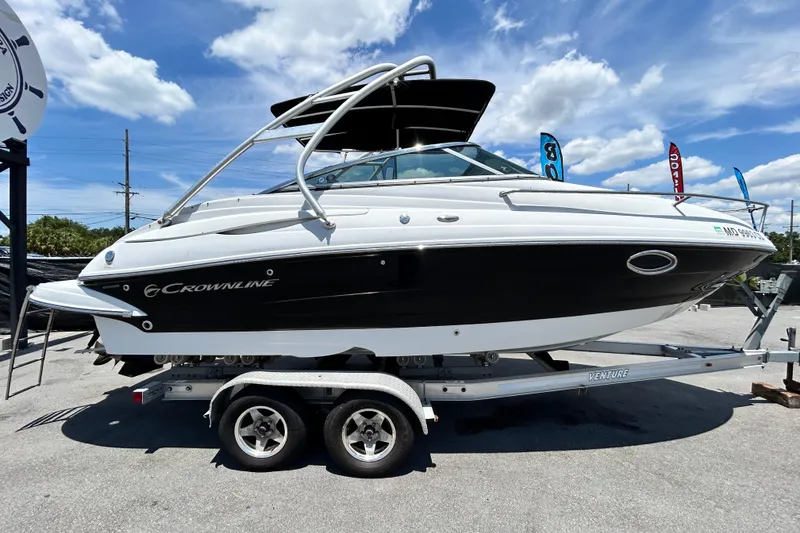 Slide: The Image of 2012 Crownline 236 SC boat on trailer under blue sky, showcasing sleek design and modern features. - 1