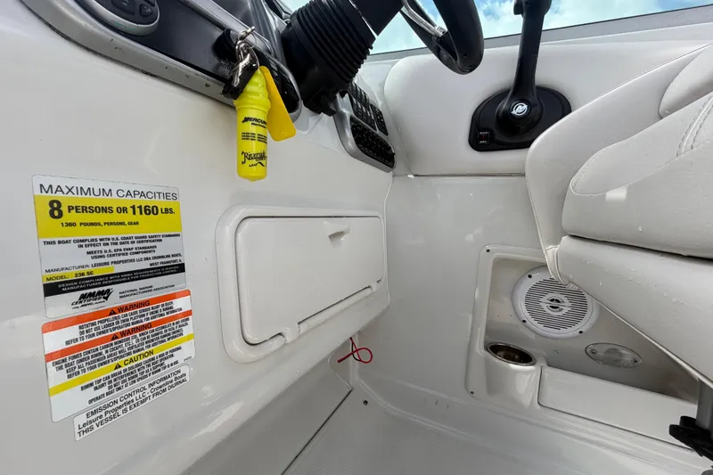 Slide: The Image of Interior of 2012 Crownline 236 SC boat showing capacity label and steering area. - 43