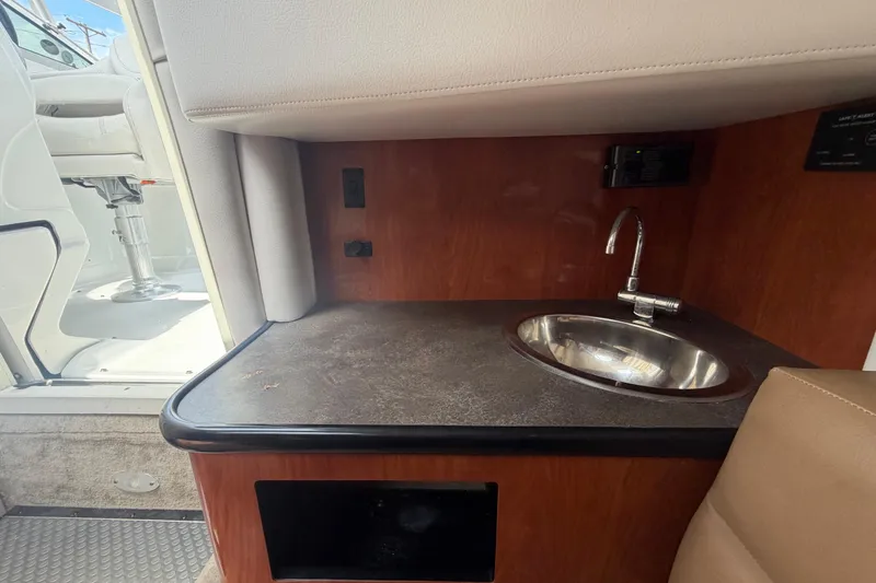 Slide: The Image of 2012 Crownline 236 SC boat interior with sink and seating area. - 59