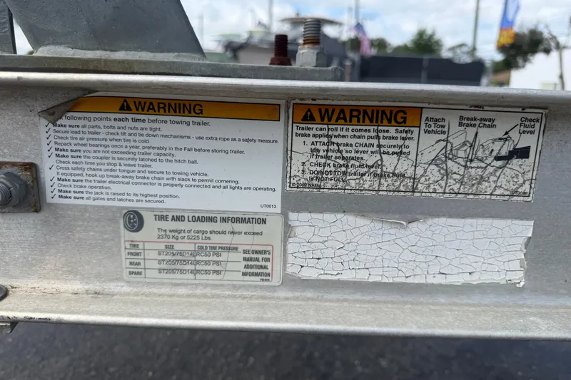 Slide: The Image of Warning labels and tire loading information on a 2012 Crownline 236 SC trailer. - 96