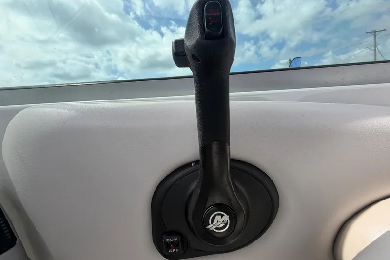 Slide: The Image of Throttle control lever on a 2012 Crownline 236 SC boat, against a cloudy sky backdrop. - 42