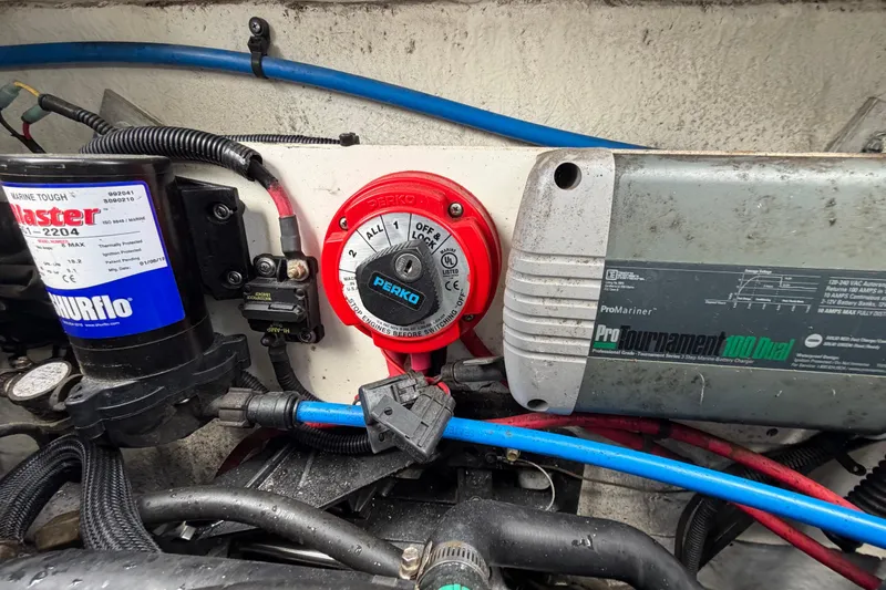 Slide: The Image of Engine compartment of 2012 Crownline 236 SC with battery switch and charger components. - 19
