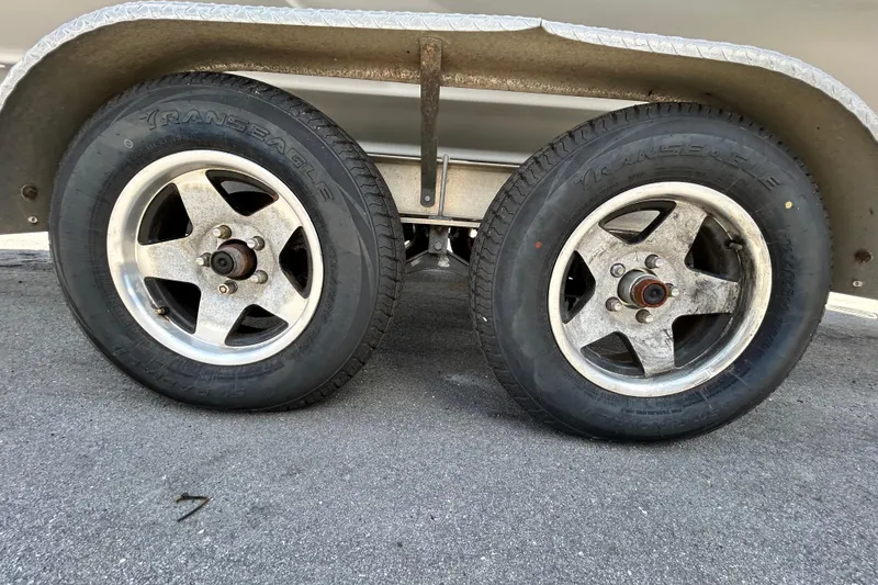 Slide: The Image of Trailer wheels of a 2012 Crownline 236 SC boat on pavement. - 98
