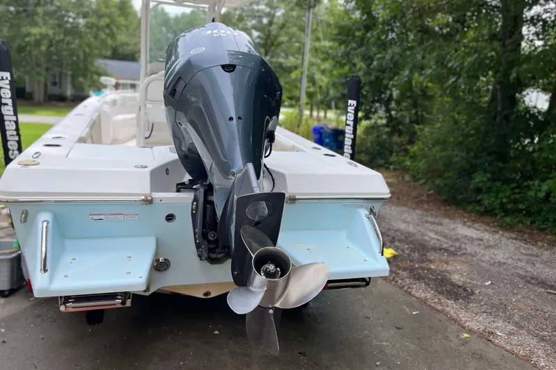 Slide: The Image of 2012 Everglades 243 Center Console boat with Yamaha outboard motor, parked outdoors. - 2