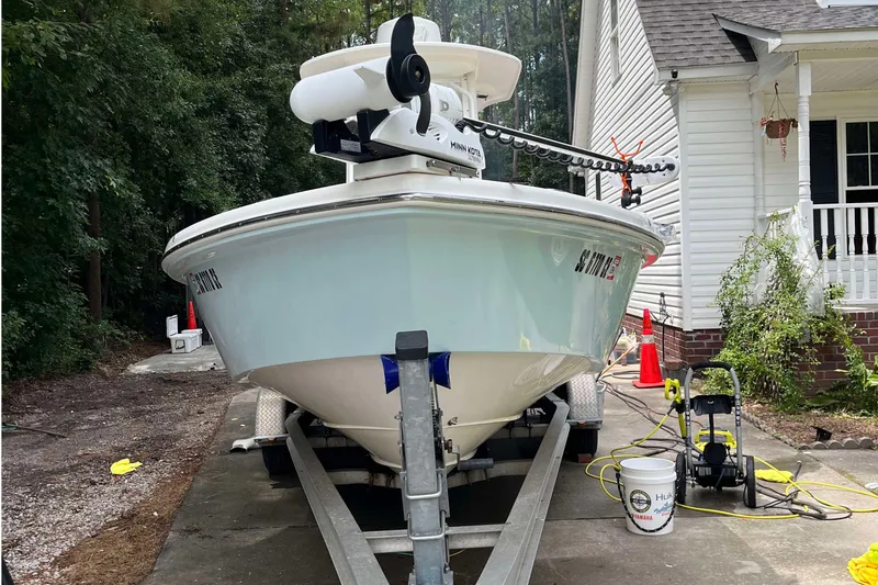 Slide: The Image of 2012 Everglades 243 Center Console boat on trailer, parked beside a house. - 1
