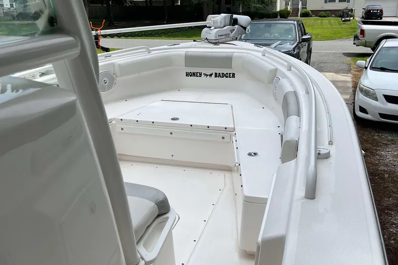 Slide: The Image of 2012 Everglades 243 Center Console boat with white interior, parked in driveway. - 4