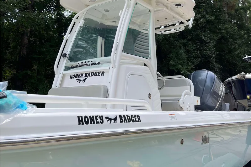 Slide: The Image of 2012 Everglades 243 Center Console boat named "Honey Badger" with sleek white design. - 0