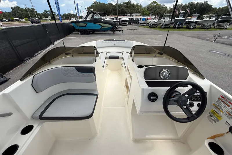 Slide: The Image of 2024 Bayliner Element M17 boat interior with steering wheel and seating area. - 18